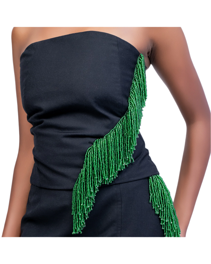 Black strapless dress with green beaded detailing on a plain background