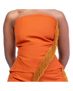 Load image into Gallery viewer, Orange strapless dress with gold fringe details on a white background
