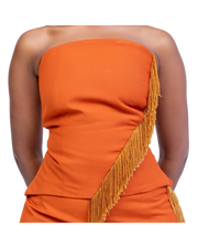 Orange strapless dress with gold fringe details on a white background