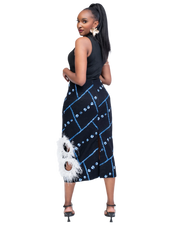 Woman wearing a black and blue patterned skirt with white feather details on a white background