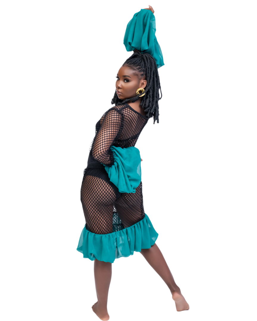 Woman wearing a black fishnet top and teal skirt with a white background